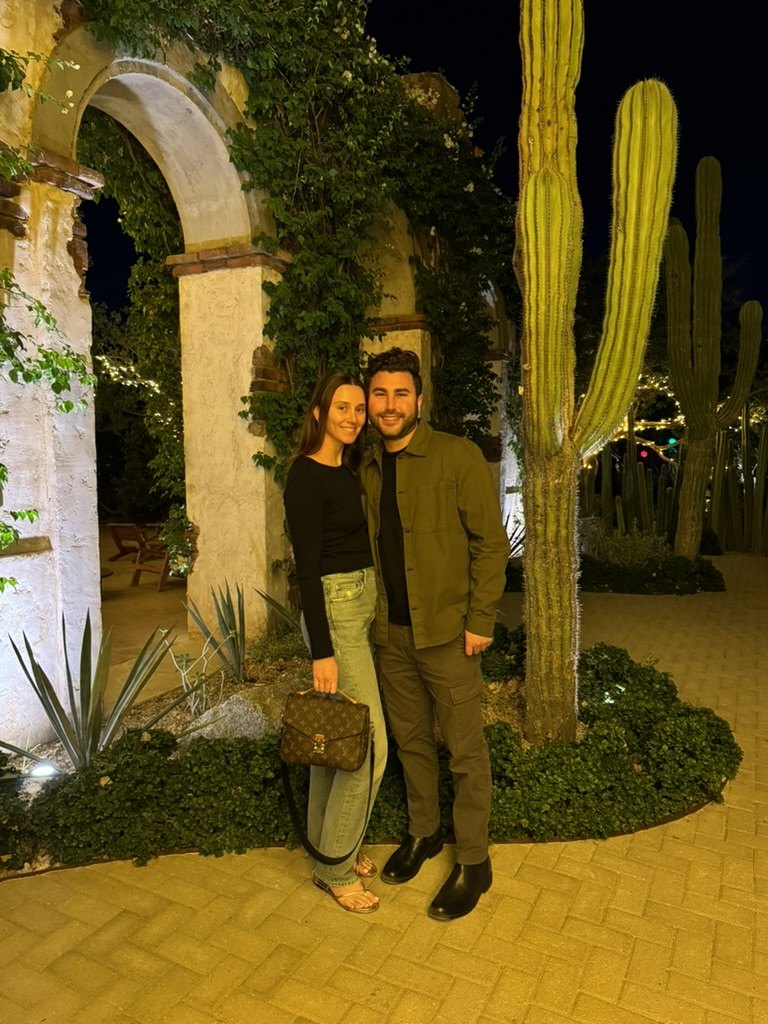 Gabriella and Joshua beside cacti after dark