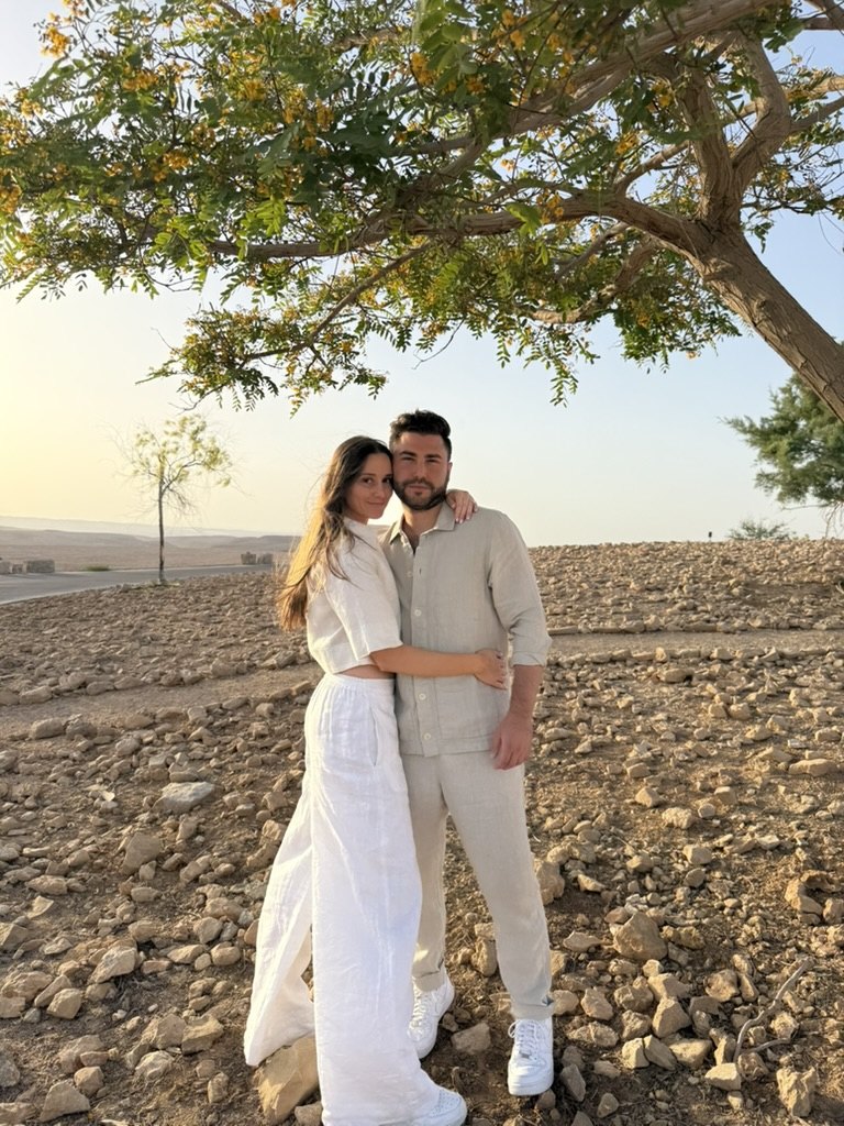 Gabriella and Joshua beneath a desert tree at golden hour
