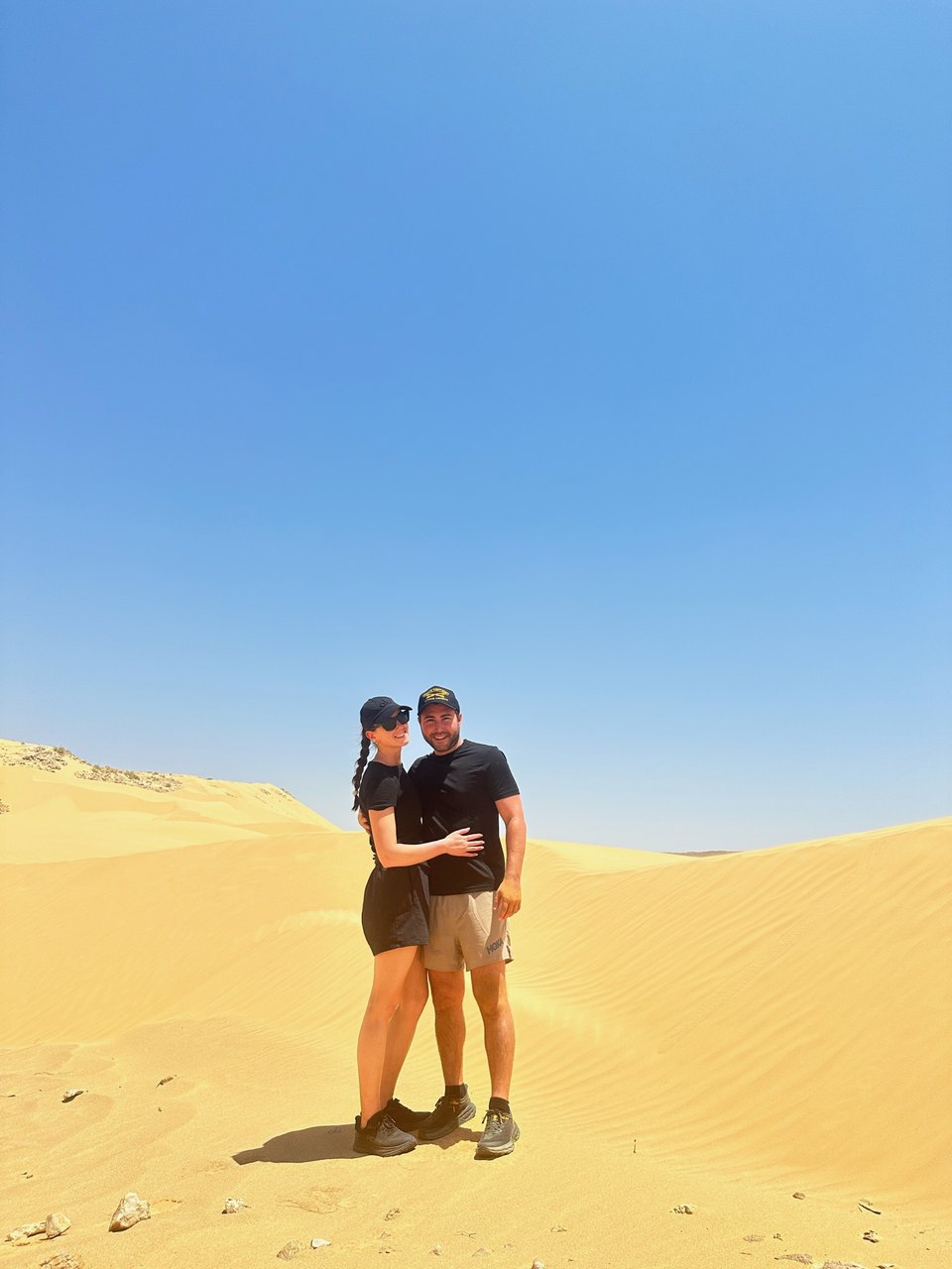 On a desert dune under a blue sky