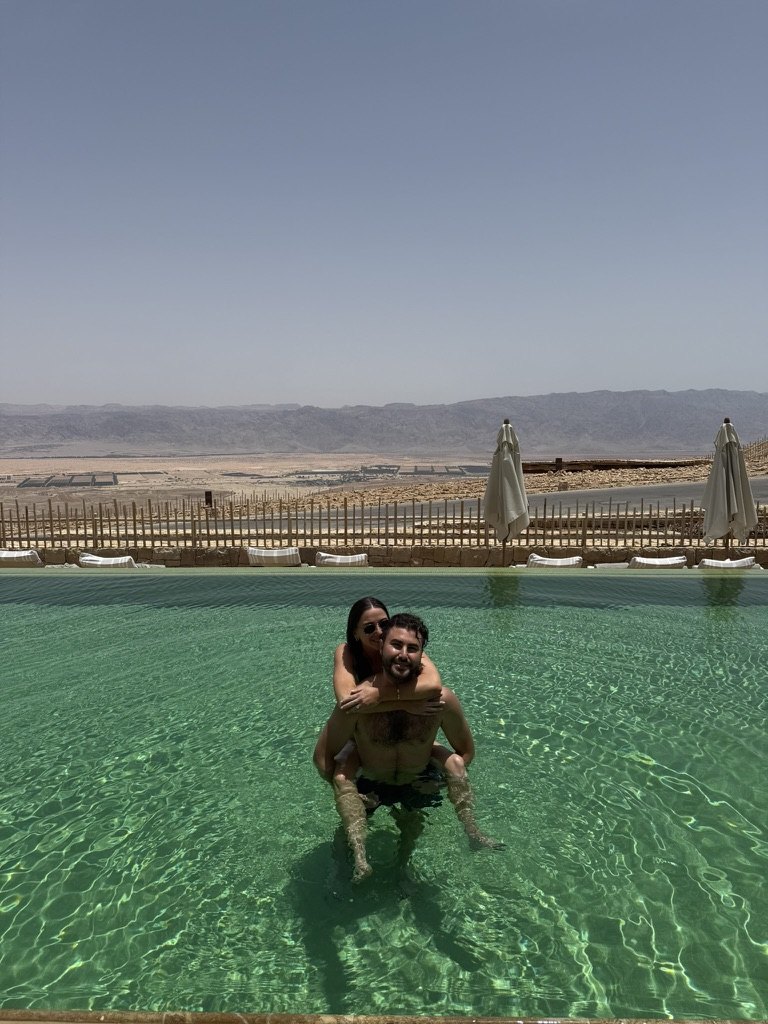 Gabriella and Joshua swimming in the resort pool overlooking the desert